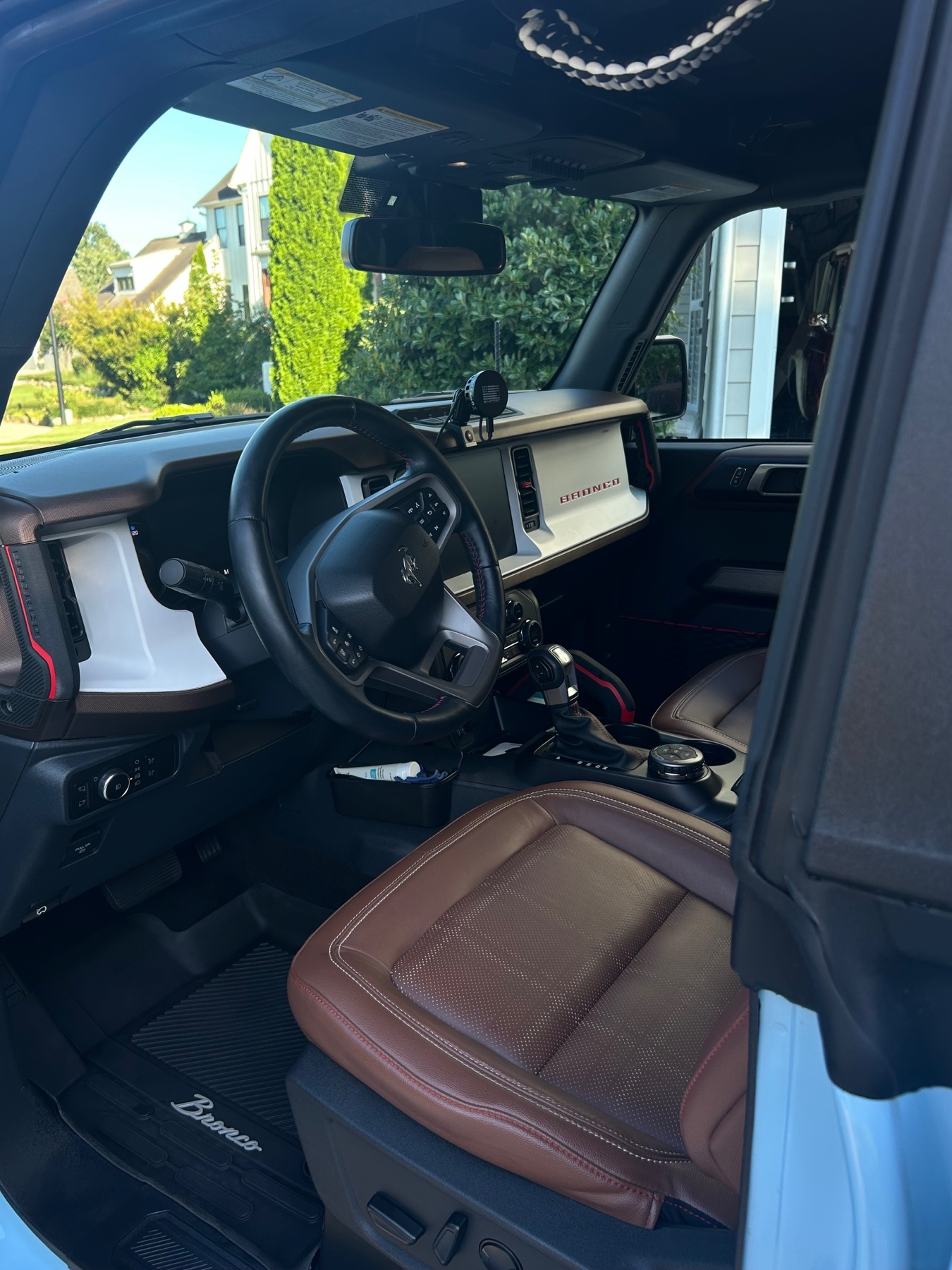Clean Ford Bronco interior showing the dashboard, steering wheel, console, seat, and floor mat